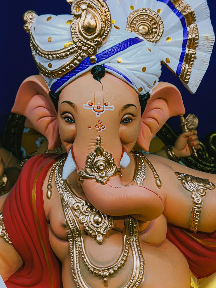Intricate close-up of a traditional Lord Ganesha sculpture adorned with gold, captured in Mumbai.