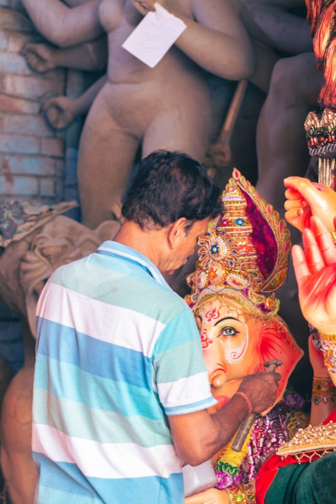 An artist carefully crafts a Ganesha idol in a Kolkata studio, showcasing traditional artistry.
